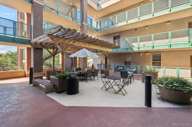 a view of a patio with dining table and chairs and potted plants