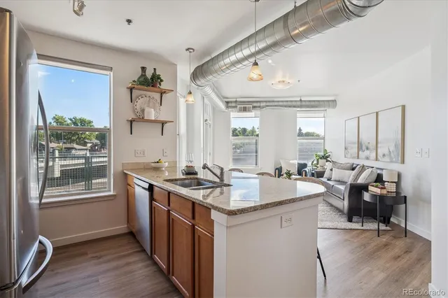 a kitchen with stainless steel appliances granite countertop sink stove and wooden floor