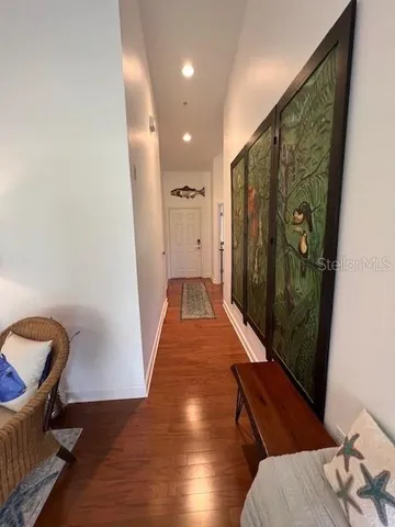 a view of a hallway with wooden floor and glass door
