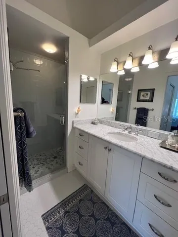 a bathroom with a shower sink and mirror