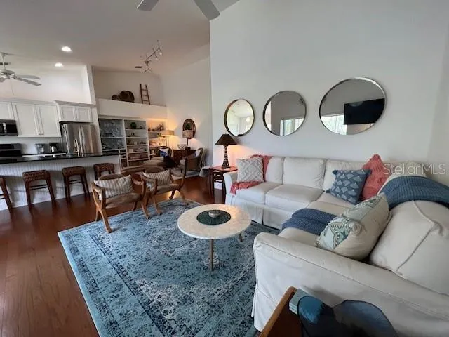 a living room with furniture a rug and kitchen view