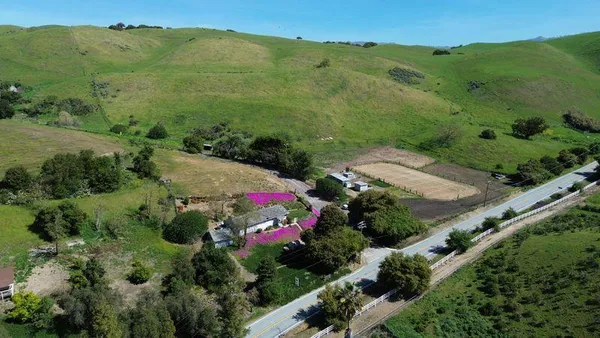 an aerial view of green landscape with trees houses and mountain view