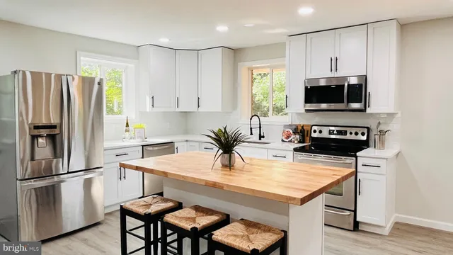 a kitchen with stainless steel appliances kitchen island granite countertop a stove a sink and a microwave