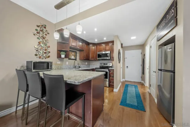 a kitchen with stainless steel appliances granite countertop a stove refrigerator sink and cabinets