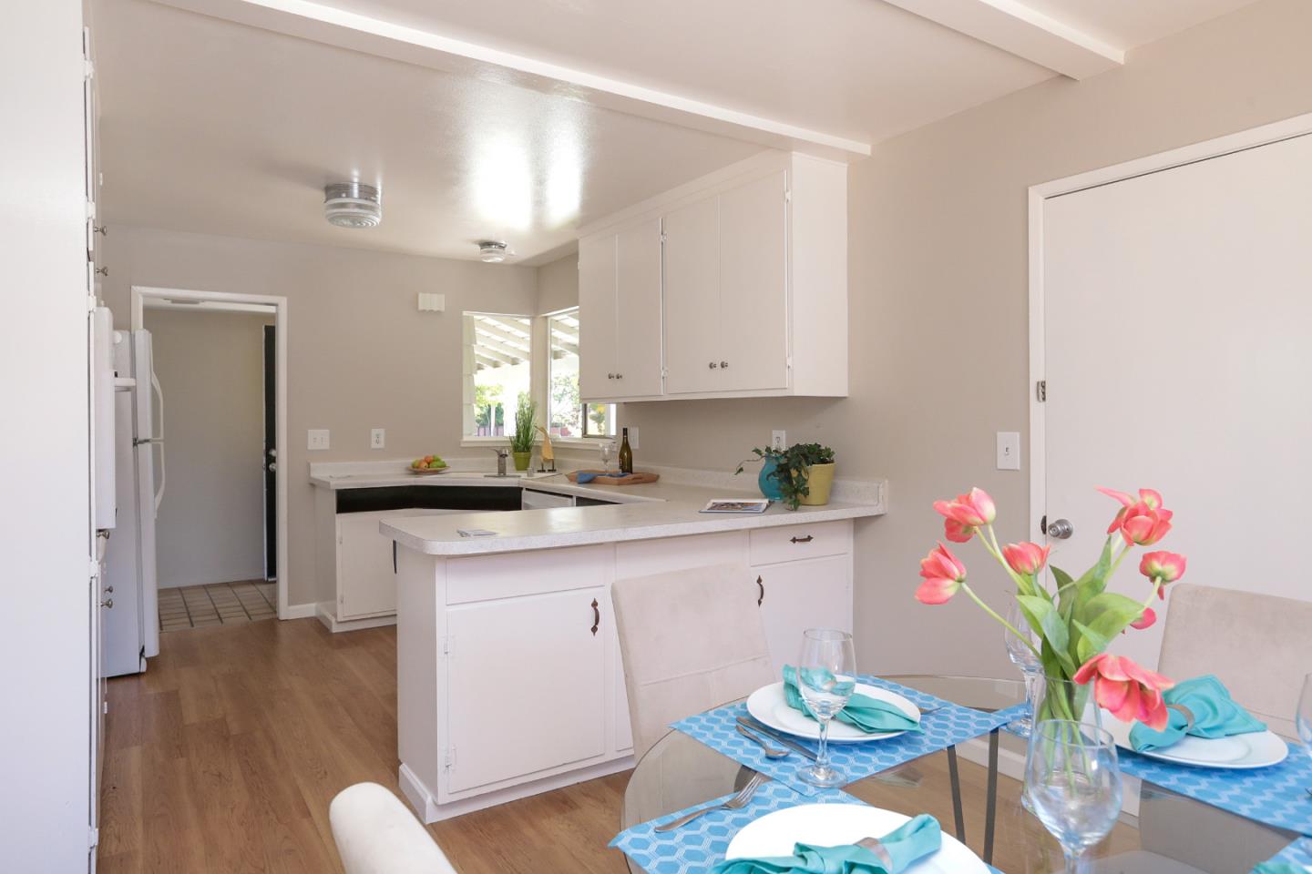 979 West Homestead Road Sunnyvale, CA 94087 - Photo 9 of 16 a kitchen with stainless steel appliances a sink a stove a dining table and chairs with wooden floor