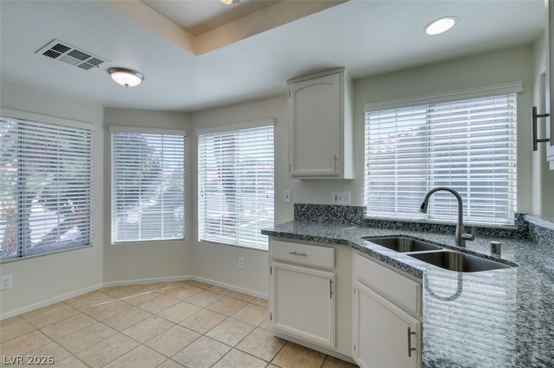 307 Cavalla Street Henderson, NV 89074 - Photo 23 of 44 A well-lit kitchen area features sleek granite countertops and a practical double-basin sink.