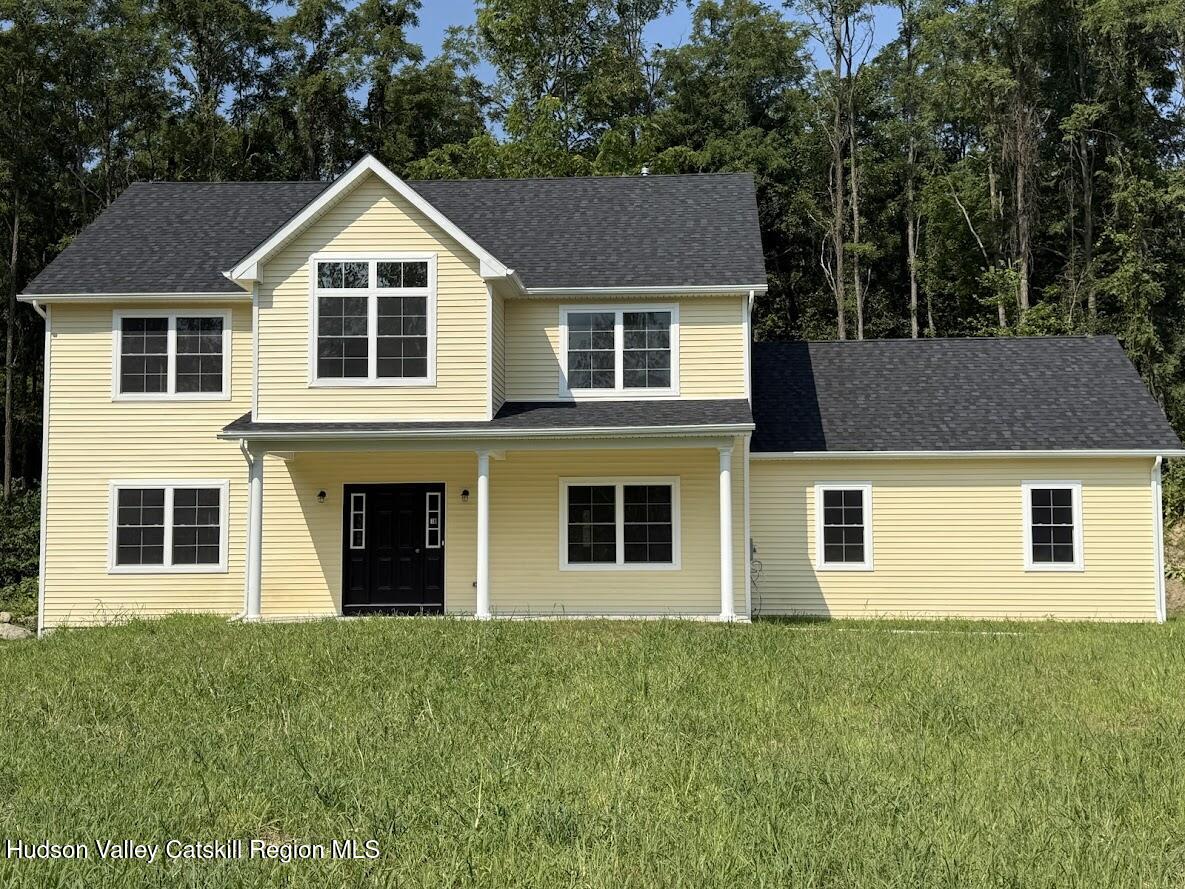 a view of a yard in front of a house with plants and large tree