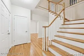 a view of staircase with wooden floor and white walls