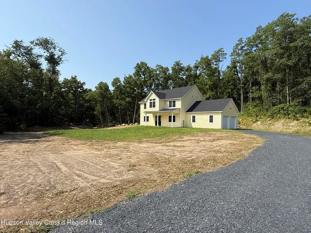 a front view of a house with yard and trees