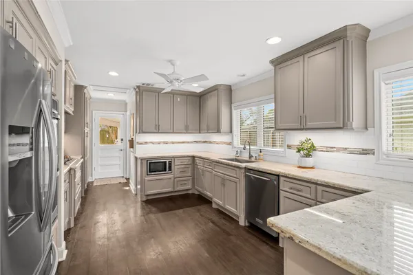 a kitchen with granite countertop a sink stove and refrigerator