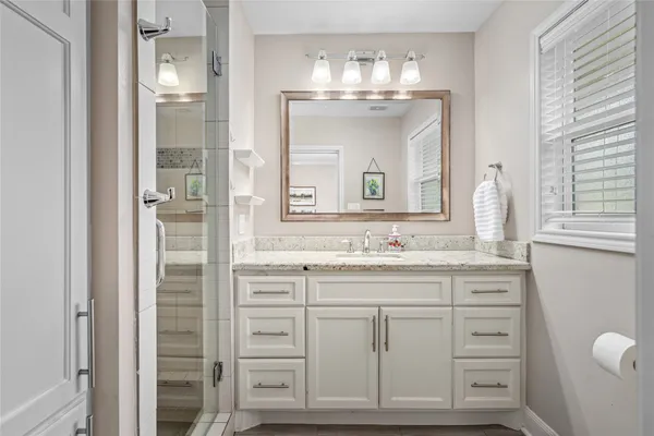 a bathroom with a granite countertop sink a mirror and a vanity