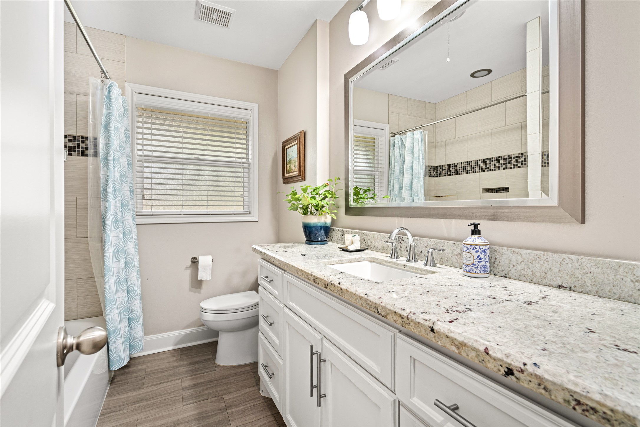 7805 Valley View Lane Houston, TX 77074 - Photo 20 of 29 a bathroom with a granite countertop sink a toilet and a mirror
