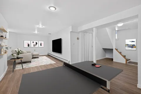 a living room with furniture pool table and a flat screen tv