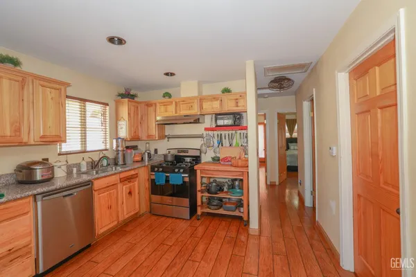 a kitchen with stainless steel appliances a stove top oven a sink and cabinets