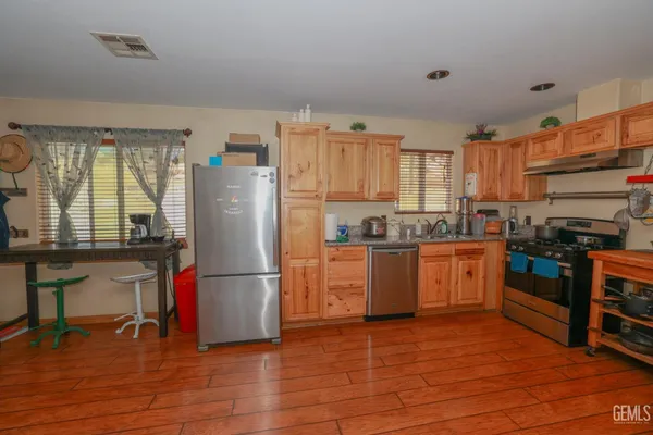 a kitchen with granite countertop a refrigerator stove top oven and sink