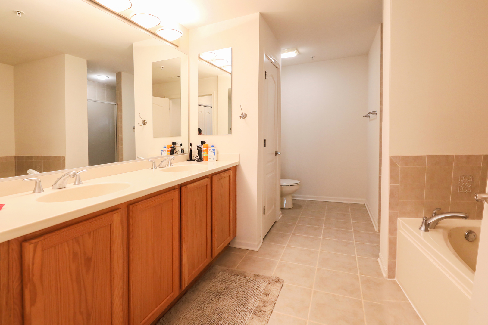 77 North Quentin Road, Unit 414 Palatine, IL 60067 - Photo 11 of 16 a bathroom with a double vanity sink a toilet and shower