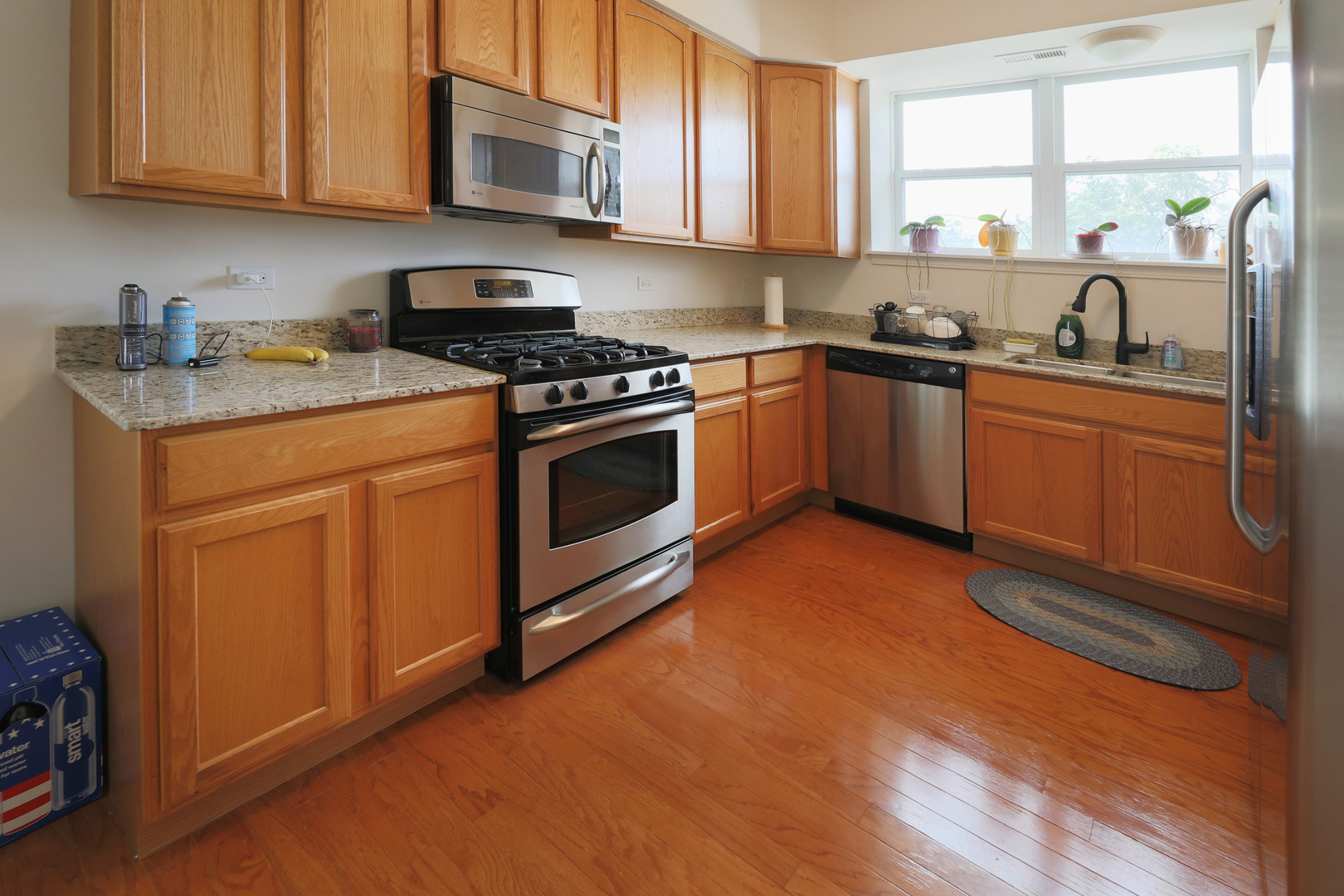 77 North Quentin Road, Unit 414 Palatine, IL 60067 - Photo 3 of 16 a kitchen with stainless steel appliances granite countertop a sink a stove a microwave cabinets and a window