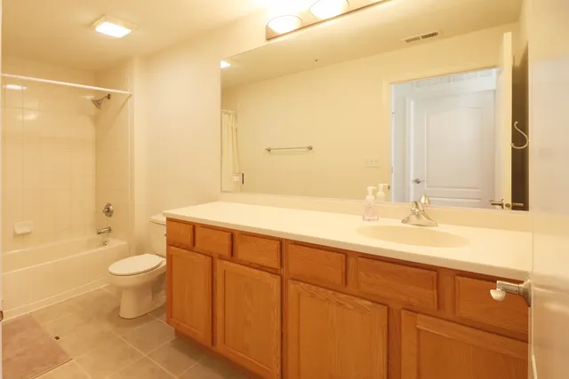 a bathroom with a double vanity sink toilet mirror and shower