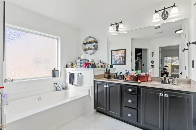 a bathroom with a tub sink and mirror
