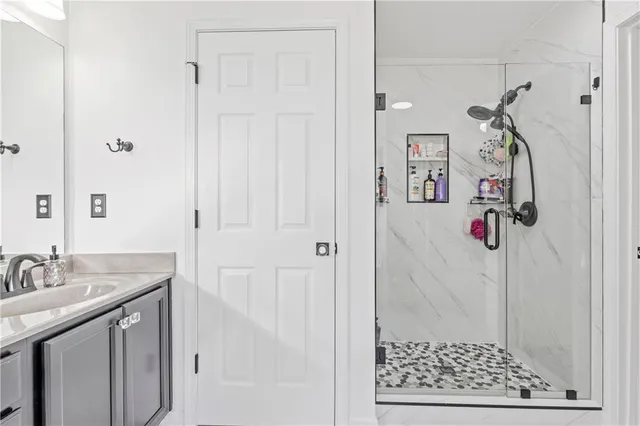 a bathroom with a sink vanity and shower