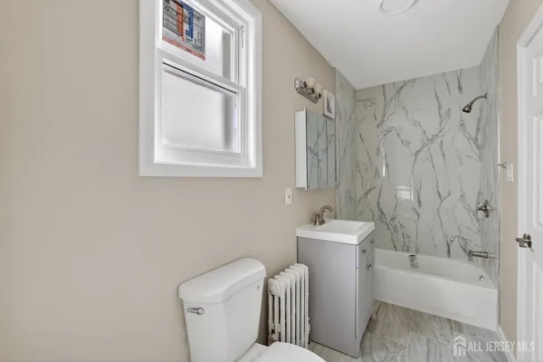 a white bath tub sitting next to a white toilet and a sink