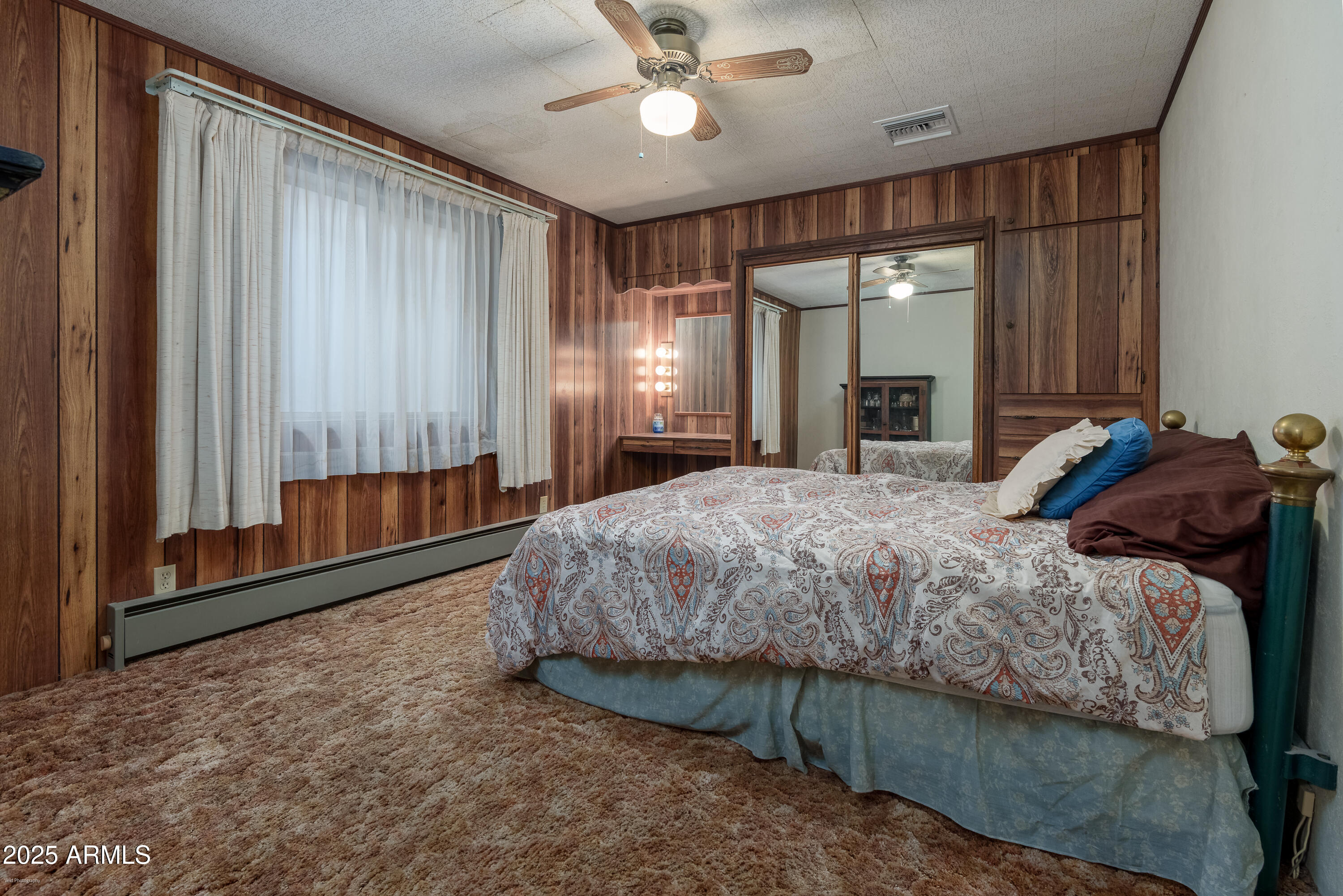 3510 East Maybe Manana Way Rimrock, AZ 86335 - Photo 18 of 36 a spacious bedroom with a bed window and a chandelier
