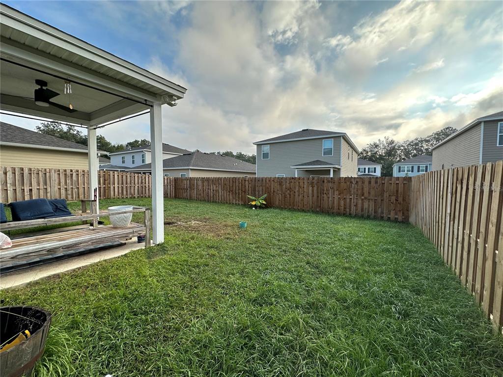 1439 Northwest 136th Street Gainesville, FL 32606 - Photo 26 of 28 a view of a backyard with sitting area and wooden fence