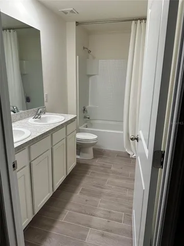 a bathroom with a double vanity sink toilet mirror and shower