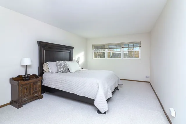 a bedroom with a bed dresser and a window