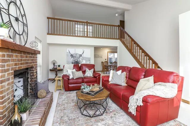 a living room with furniture a fireplace and a flat screen tv
