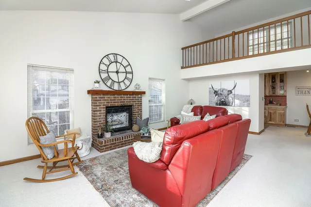 a living room with furniture a fireplace and a window