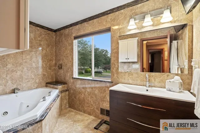 a bathroom with a bathtub sink and mirror