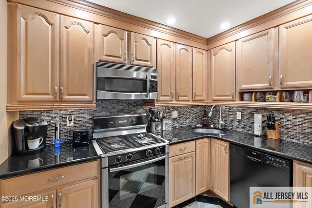 a kitchen with stainless steel appliances granite countertop a stove a sink and a microwave
