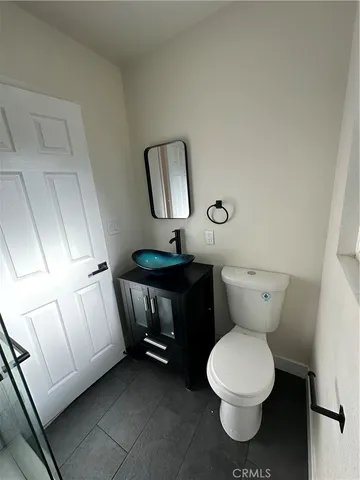 a bathroom with a toilet a sink and mirror
