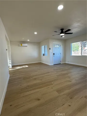 an empty room with fan and windows