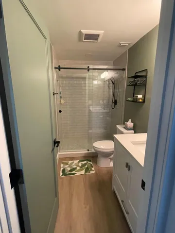 a bathroom with a double vanity sink toilet mirror and shower