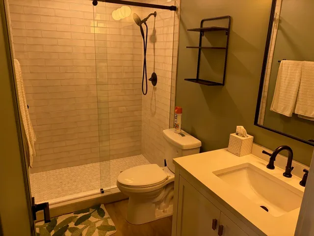 a bathroom with a sink a toilet and shower
