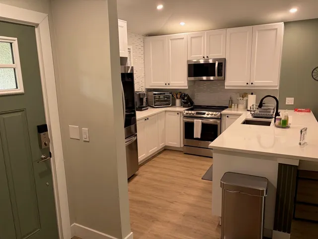 a kitchen with a sink a stove a refrigerator and cabinets