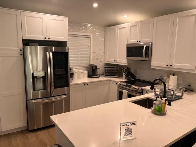 a kitchen with stainless steel appliances a refrigerator sink and microwave