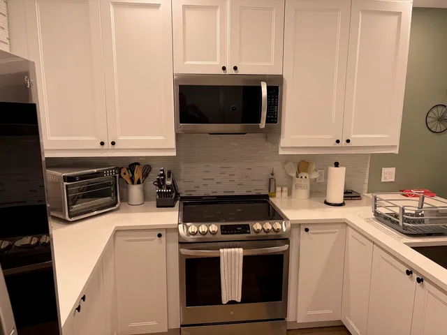 a kitchen with stainless steel appliances a stove and a microwave