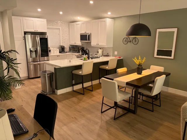 a kitchen with a dining table chairs and a refrigerator