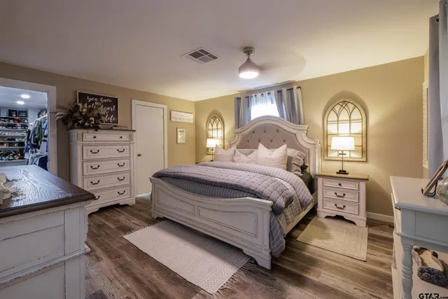 a spacious bedroom with a bed and a dresser