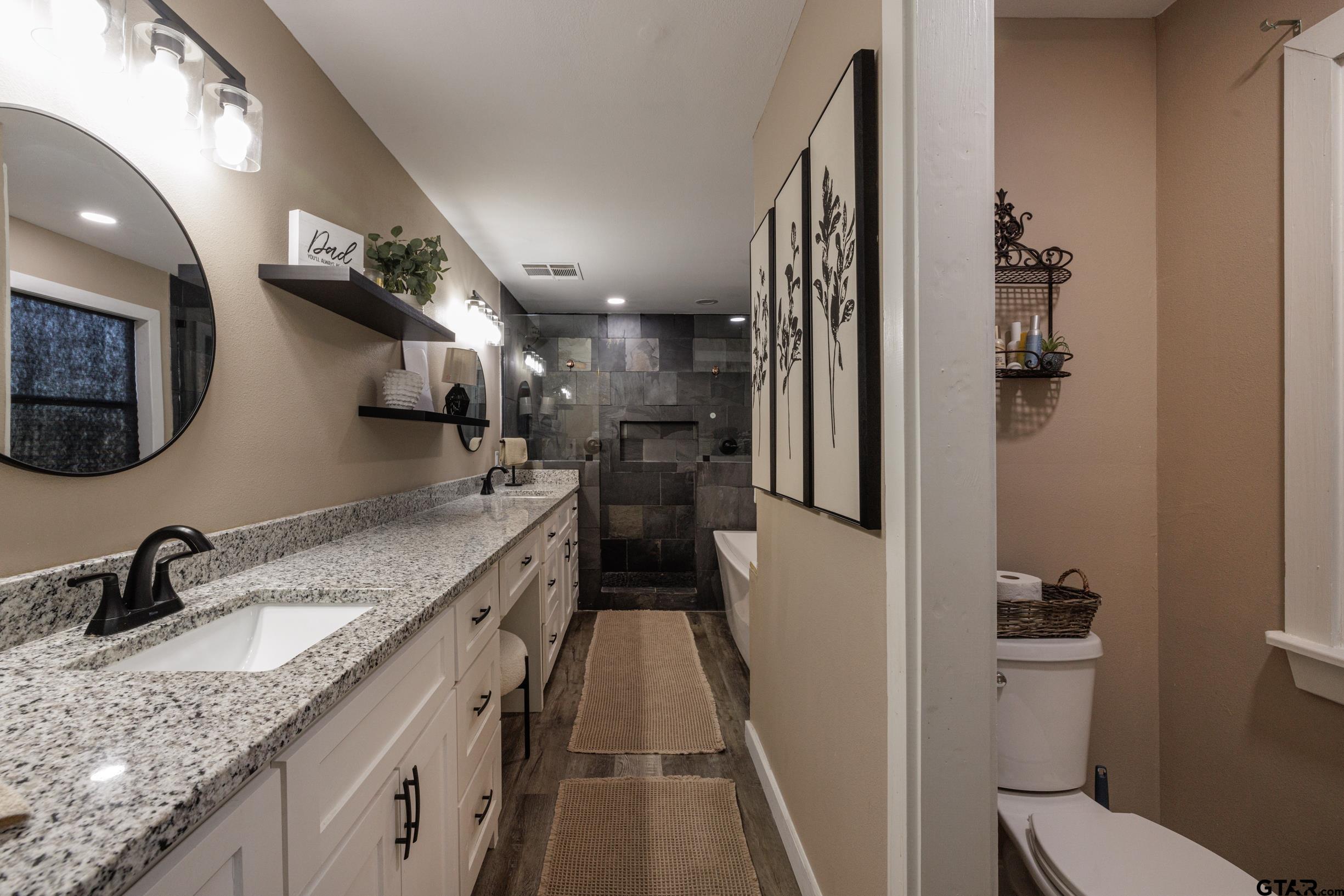 765 County Road 3410 Emory, TX 75440 - Photo 14 of 38 a bathroom with a granite countertop sink a toilet and a mirror