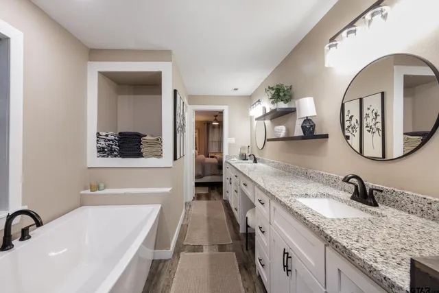 a bathroom with a granite countertop sink and a mirror