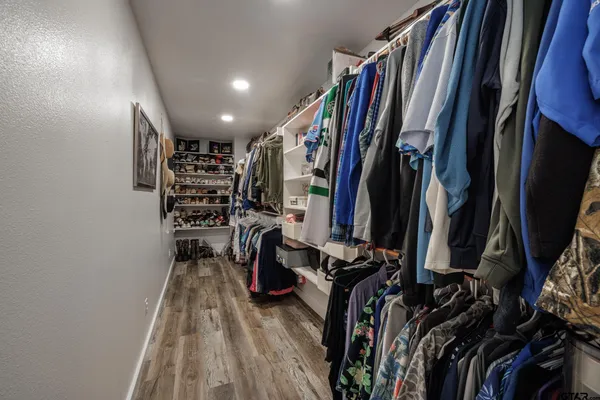 a view of walk in closet with clothes