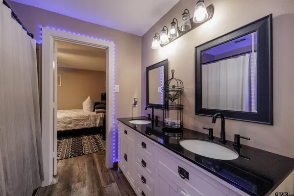 a en suite bathroom with a granite countertop sink and a mirror