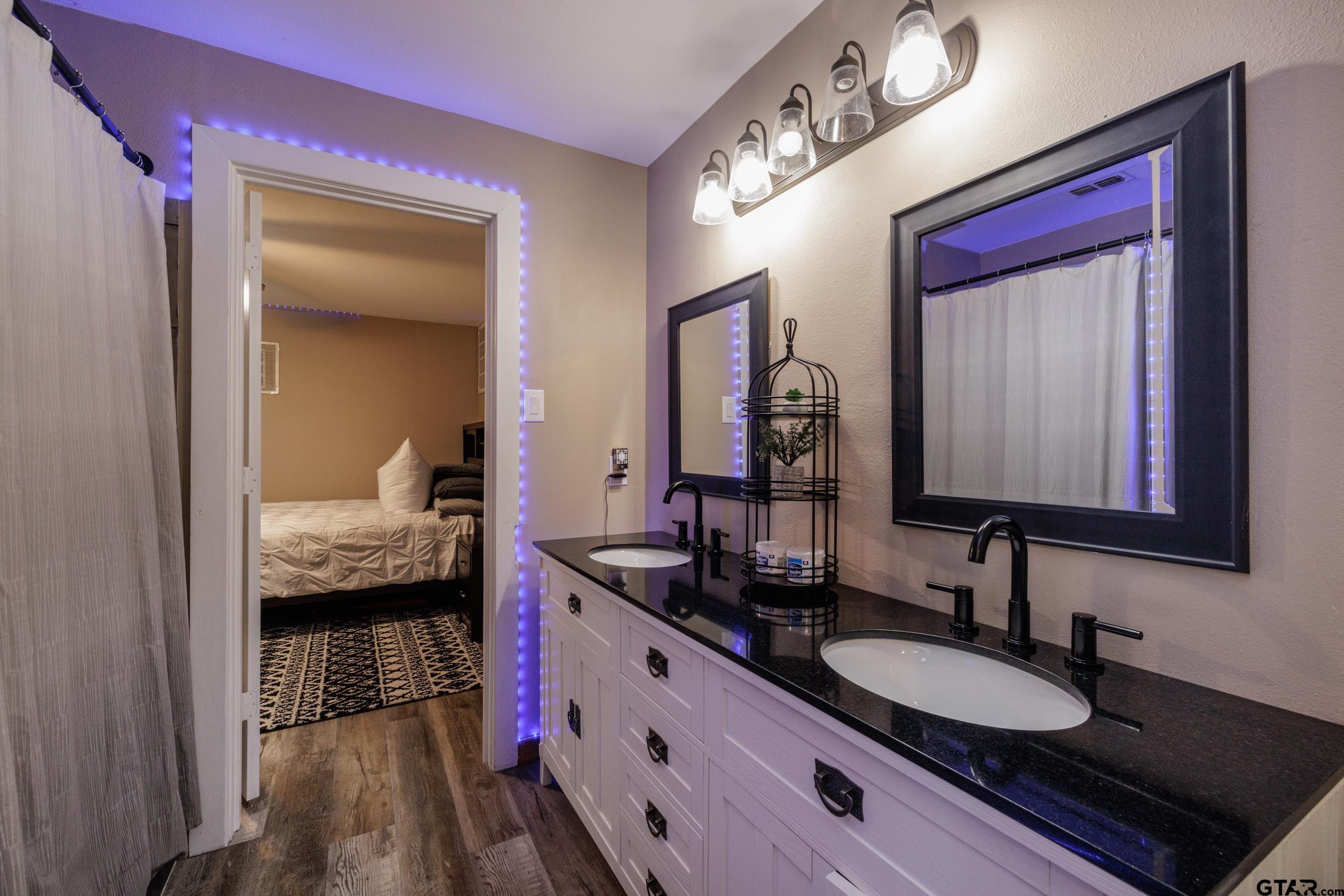 765 County Road 3410 Emory, TX 75440 - Photo 21 of 38 a en suite bathroom with a granite countertop sink and a mirror