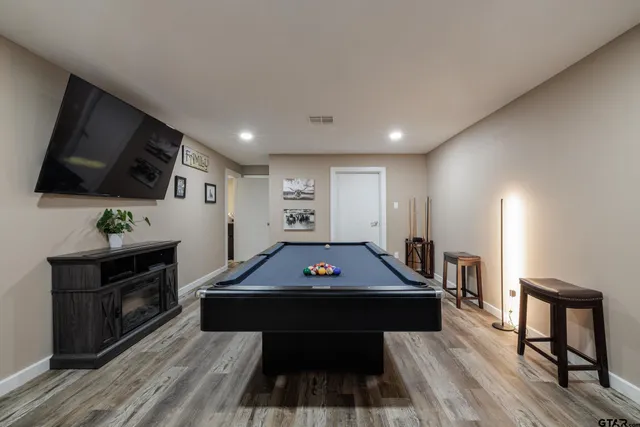 a living room with furniture flat screen tv and pool table