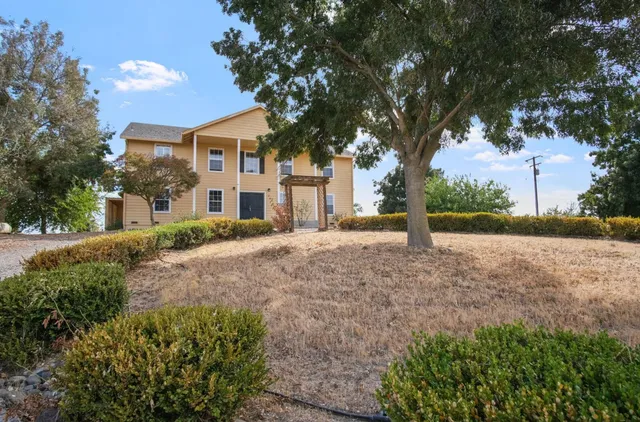 a view of a house with a tree in the yard