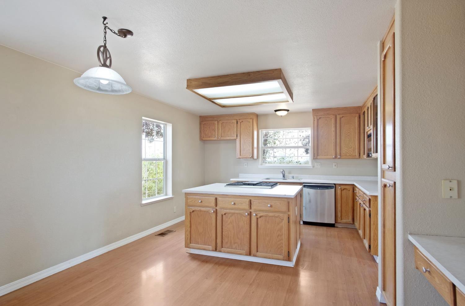 18624 Lake Road Hickman, CA 95323 - Photo 14 of 34 a kitchen with a stove window and wooden floor